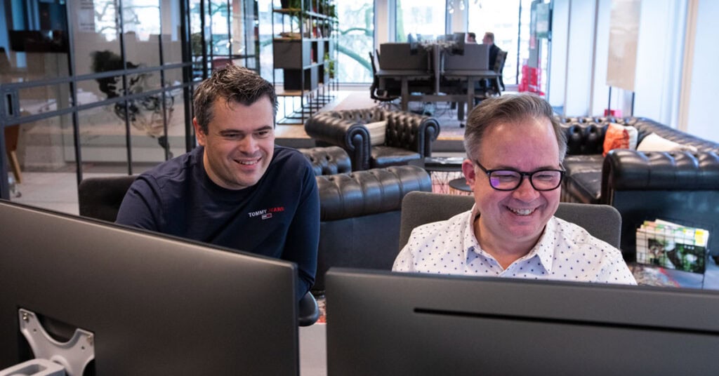 foto van twee mannen achter de computer op kantoor